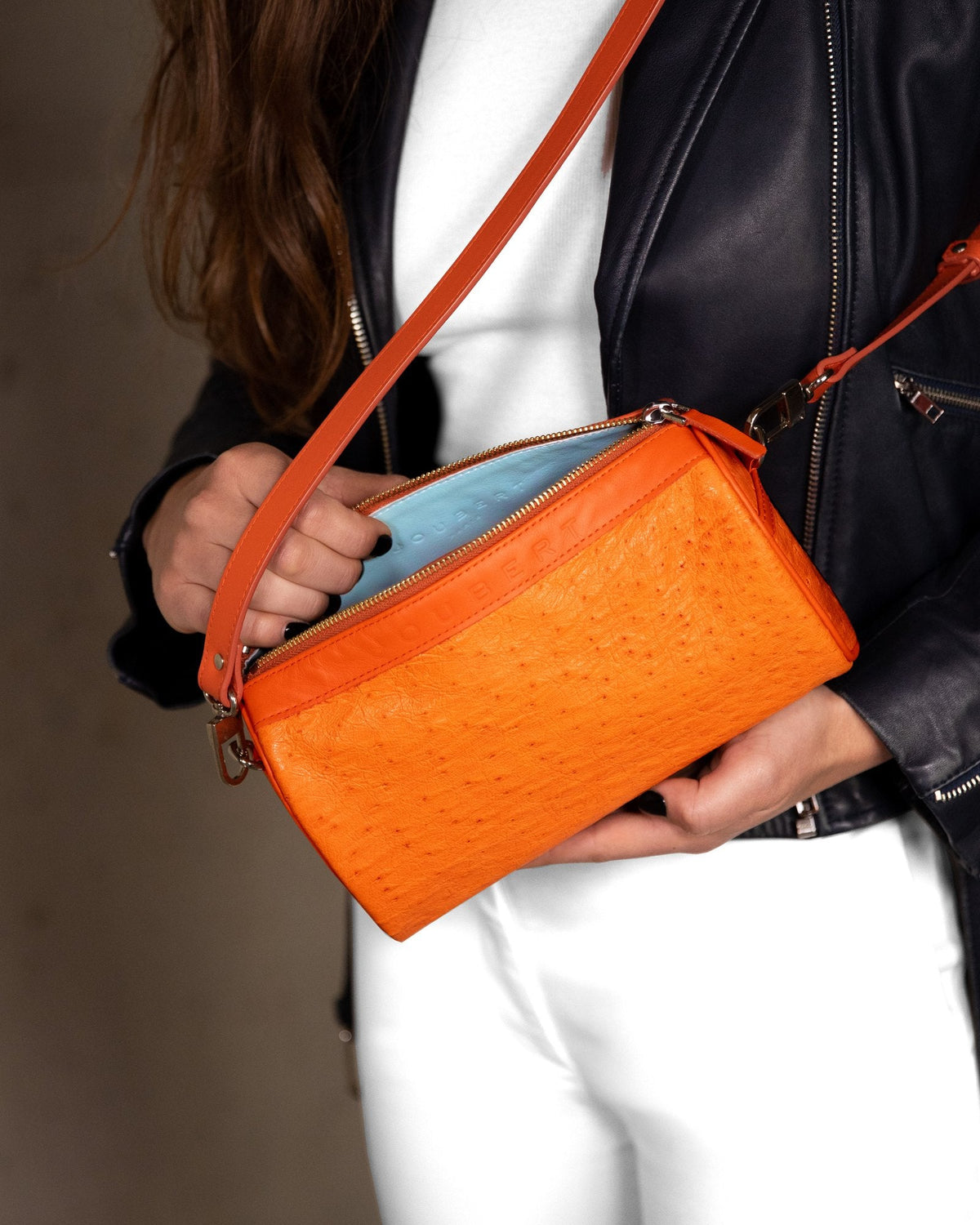 Sac 22 en cuir d'autruche orange, porté en bandoulière