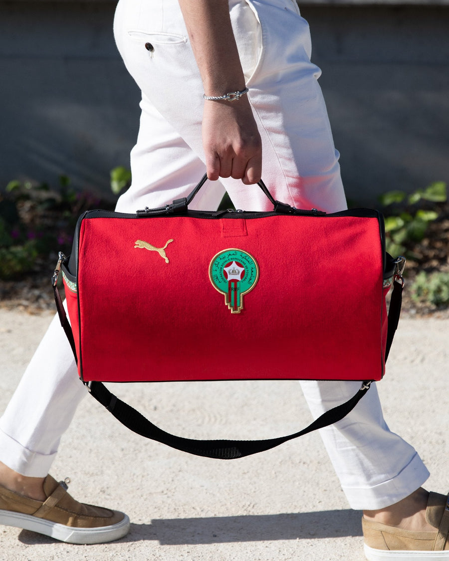 Sac JOUBERT fait d'un maillot rouge du Maroc, porté à la main avec sa bandoulière