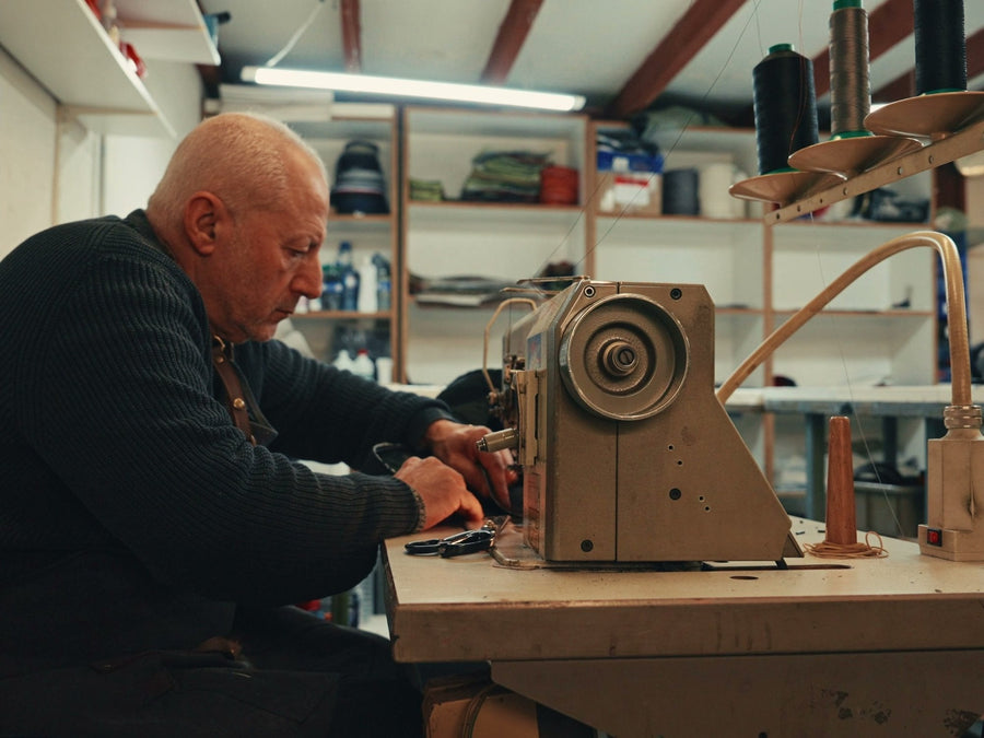Un artisan de l'atelier JOUBERT à la machine à coudre