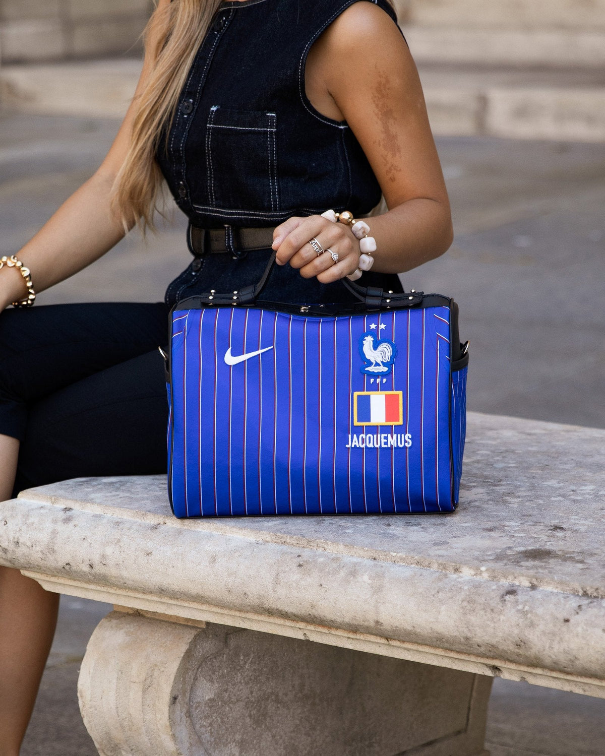 Le sac Métamorphose 30 cm France × Jacquemus posé sur un banc de pierre