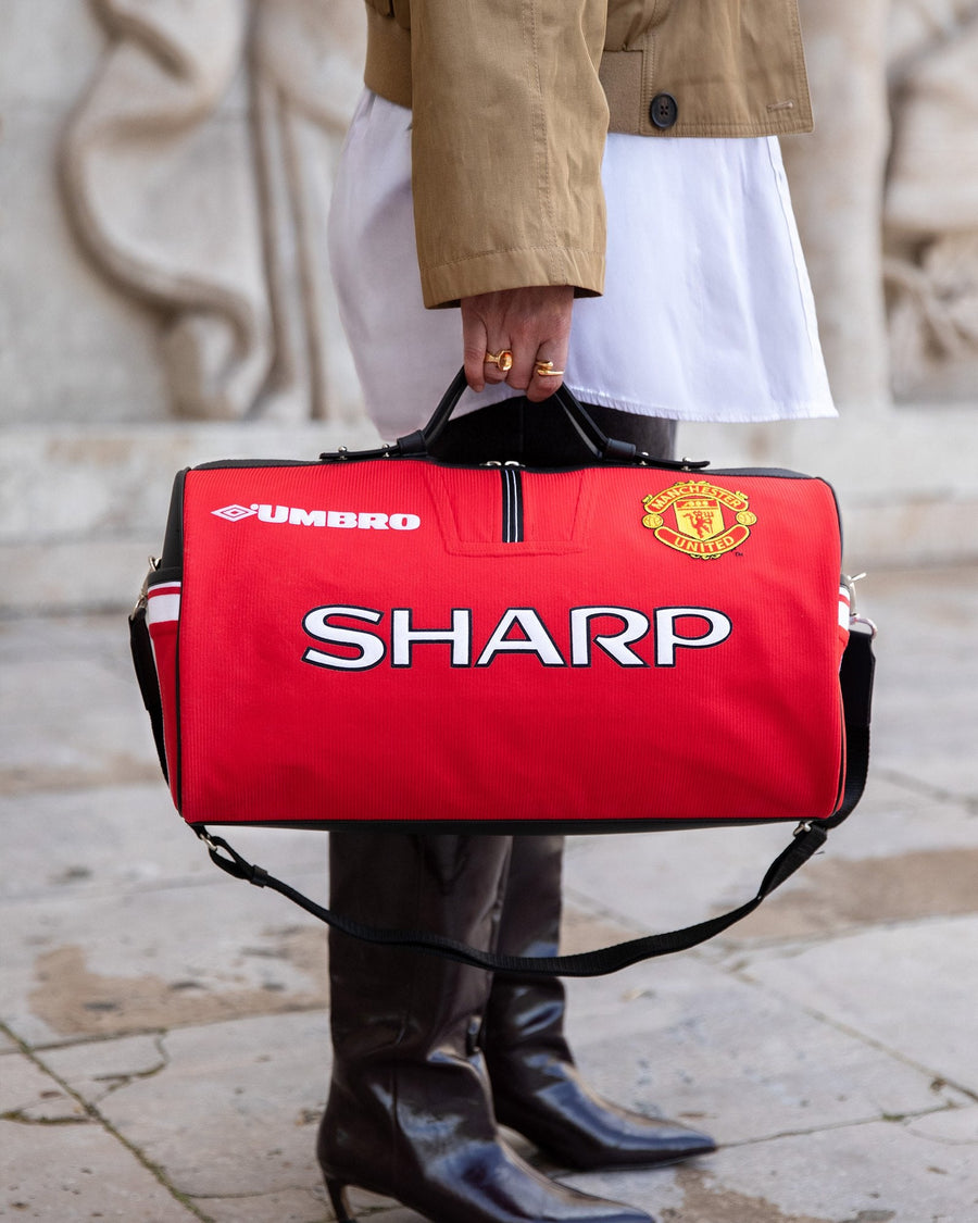 Le sac JOUBERT fait du maillot de Manchester United, sponsor Sharp, porté à la main