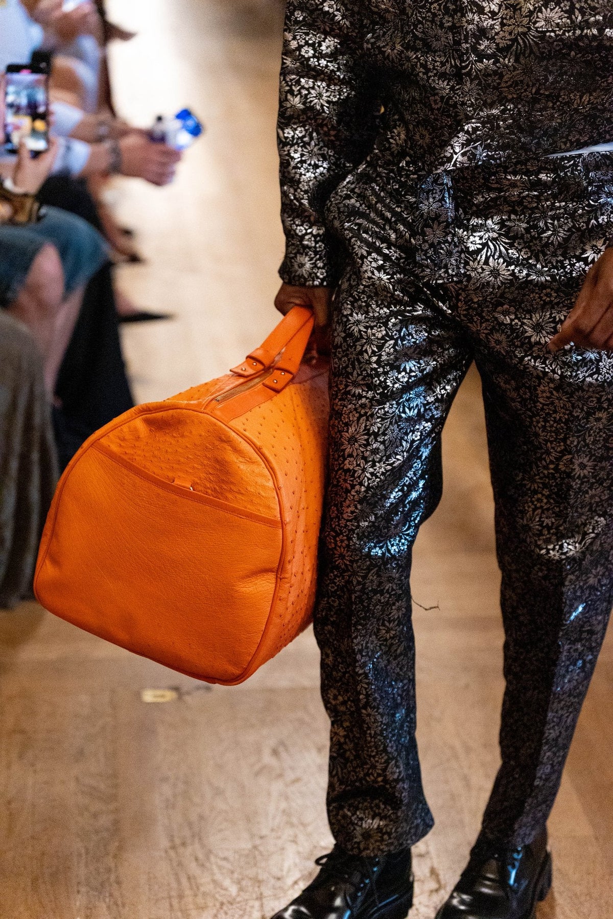 Un sac JOUBERT en autruche orange sur le podium du défilé Christian Manzala