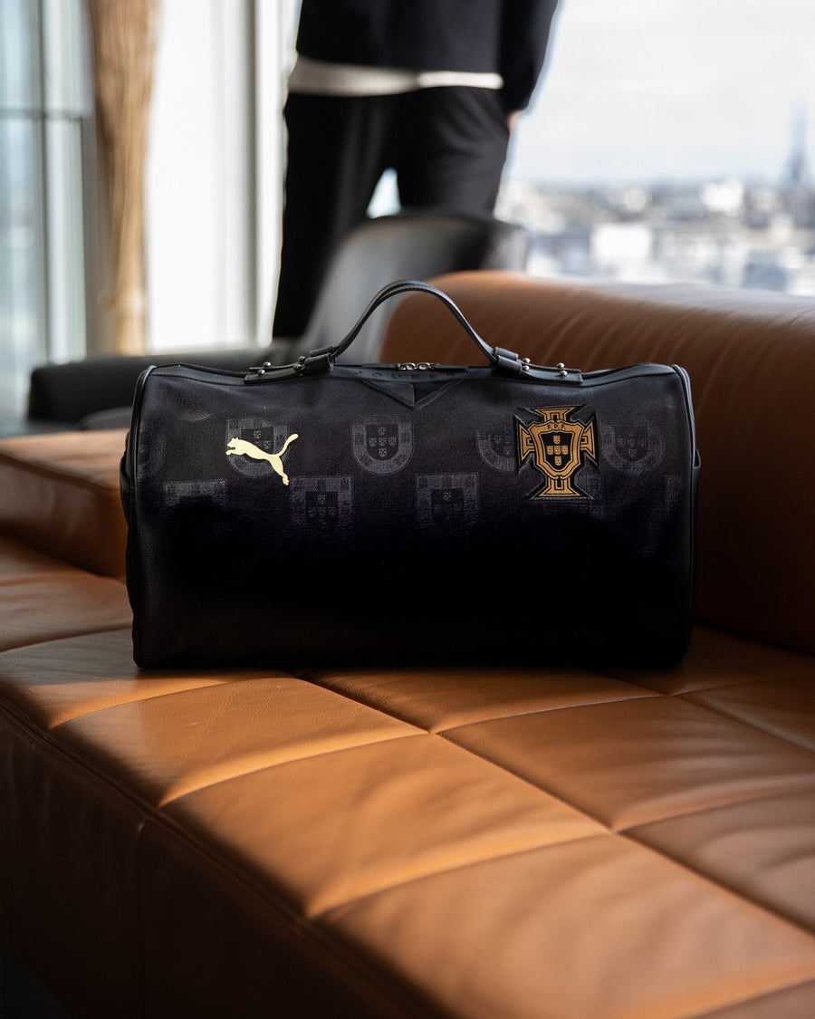 Le sac JOUBERT fait du maillot noir du Portugal, posé sur un canapé en cuir