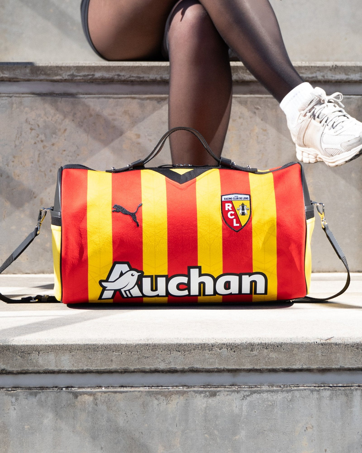 Sac 45 taillé dans le maillot sang et or du RC Lens, posé sur des marches