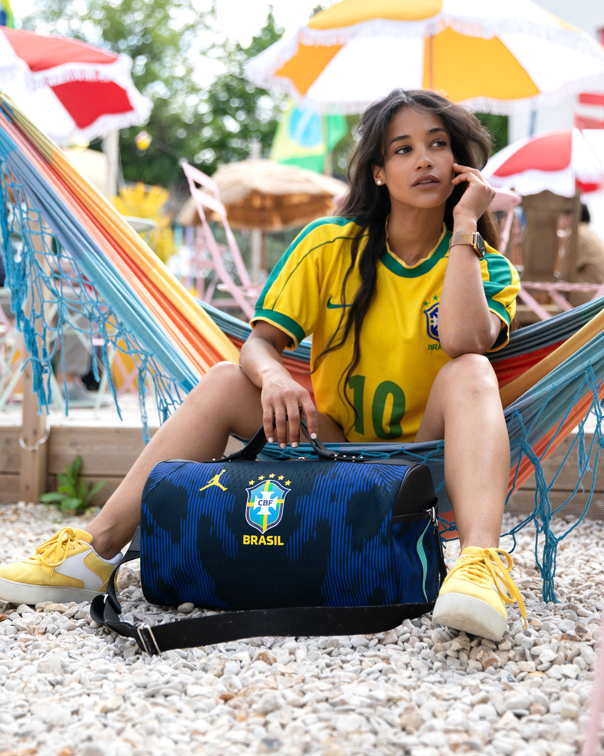 Sac 45 Métamorphose en maillot du Brésil aux pieds d'une femme en maillot jaune assise dans un hamac