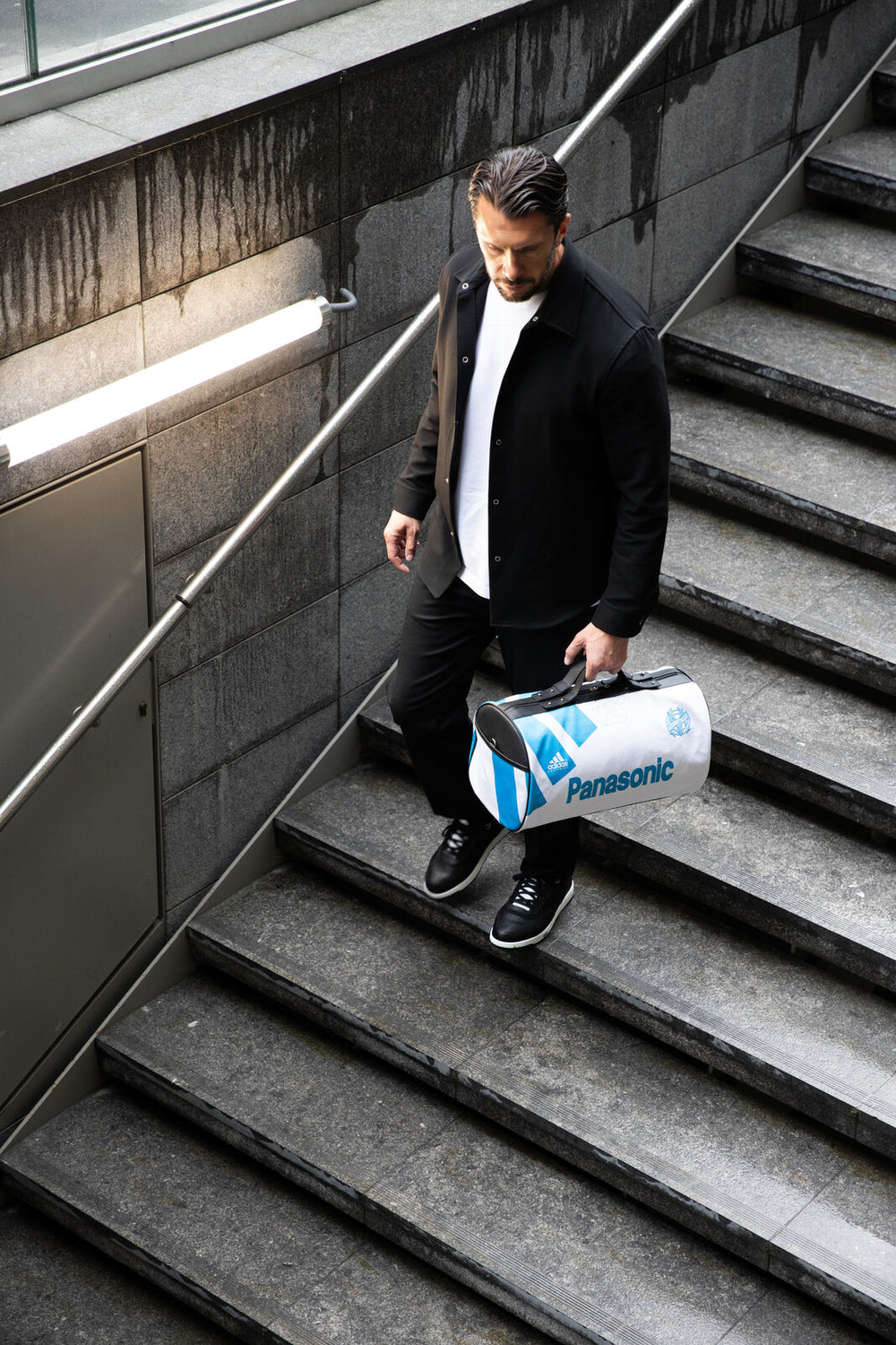 White Métamorphose bag in an Olympique de Marseille jersey, carried on a staircase at Porte Maillot.