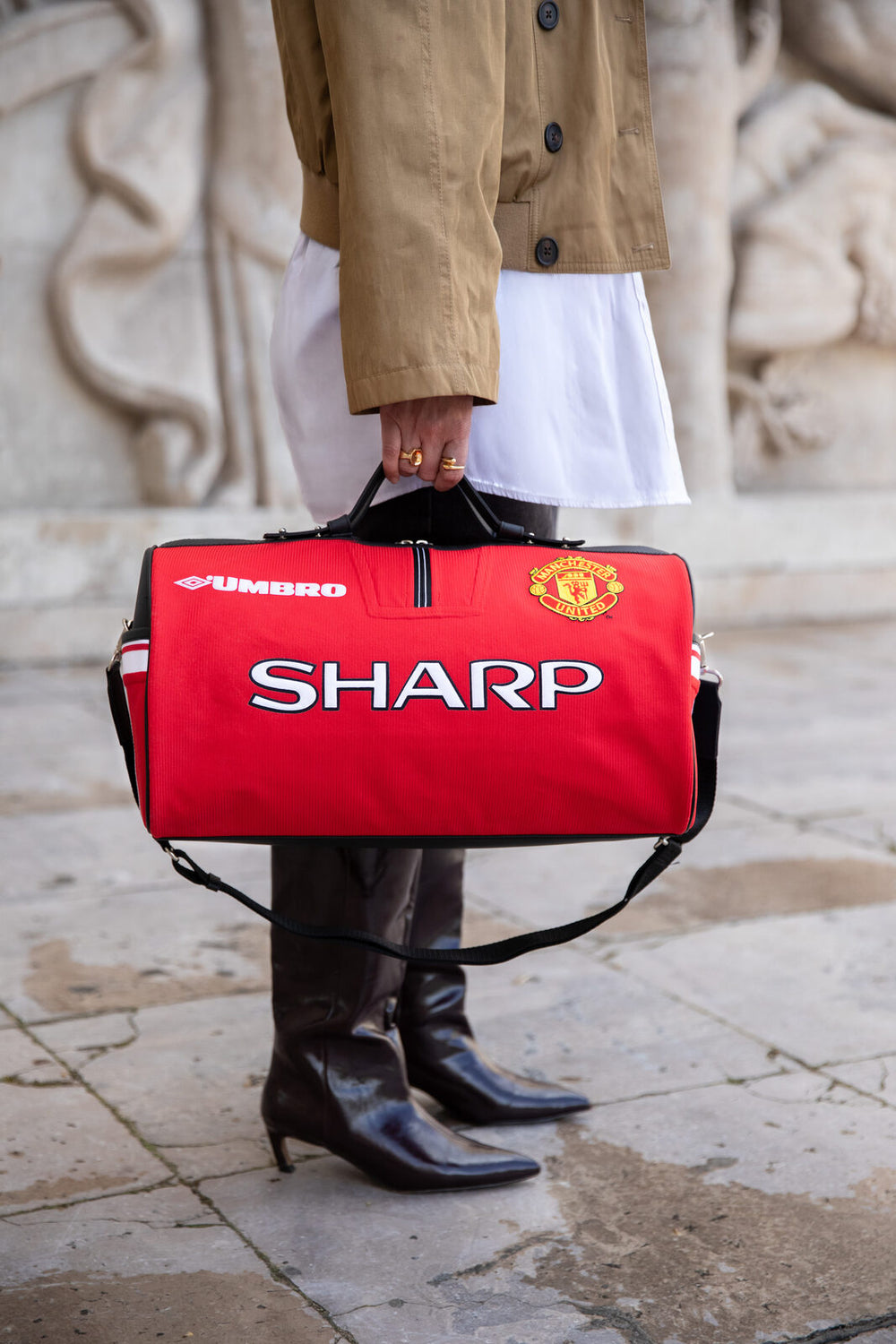 Red Métamorphose bag in a Manchester United jersey, carried outside the Palais de Tokyo in Paris.
